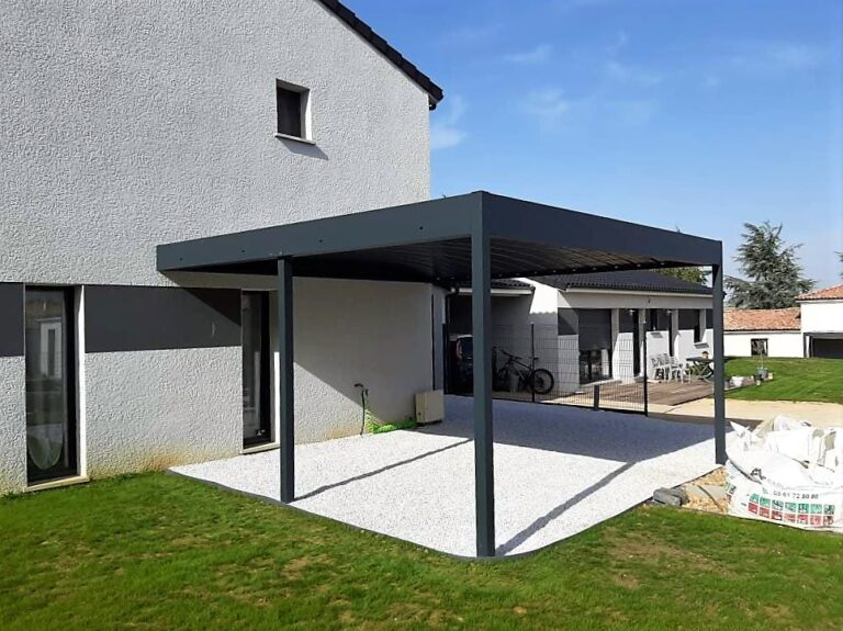 Pergola bioclimatique grise devant une maison moderne avec patio en gravier blanc et pelouse. Numéro: 05 61 72 80 80.