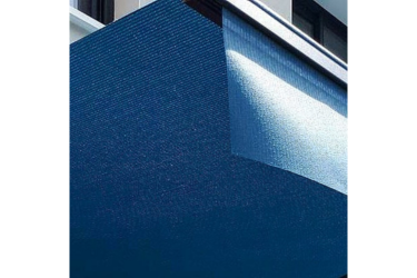 Store extérieur en maille bleu marine sur une façade de bâtiment, filtrant la lumière du soleil.