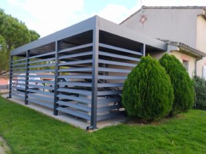 Carport métallique gris à lames horizontales avec van Stores Pergolas Protection et plaque DC-547, près d'une maison.