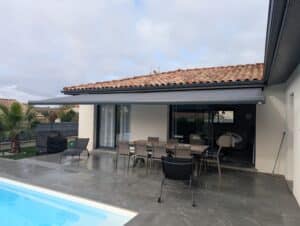 Terrasse moderne avec store banne gris déployé.