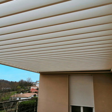 Pergola moderne beige à lames orientables blanches couvrant une terrasse extérieure.
