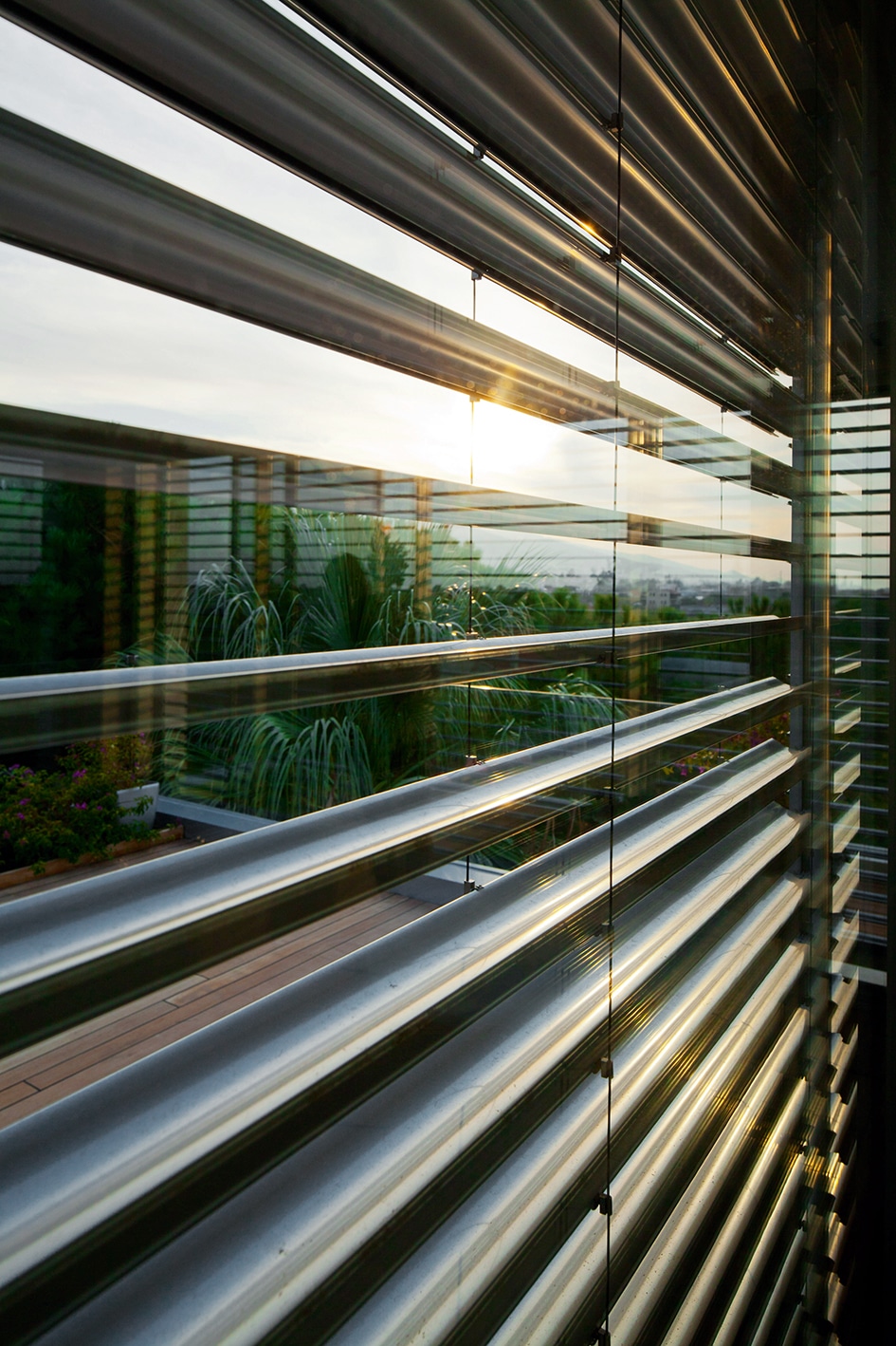 réfléchissant le soleil devant une terrasse végétalisée et moderne.