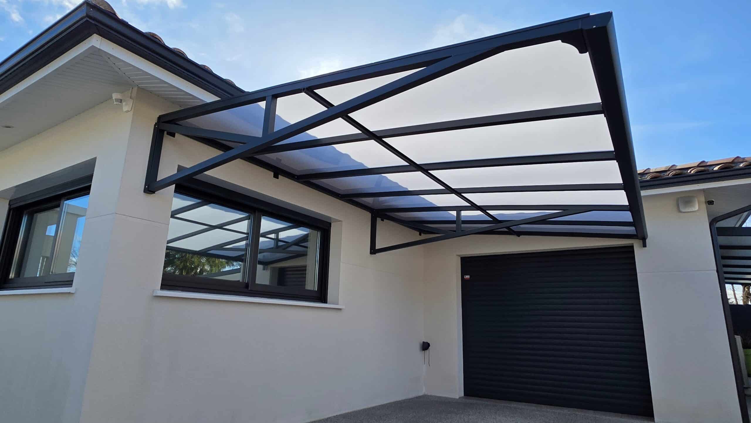 Carport design en métal noir avec toit translucide sur maison moderne, abri voiture sans poteau au sol.