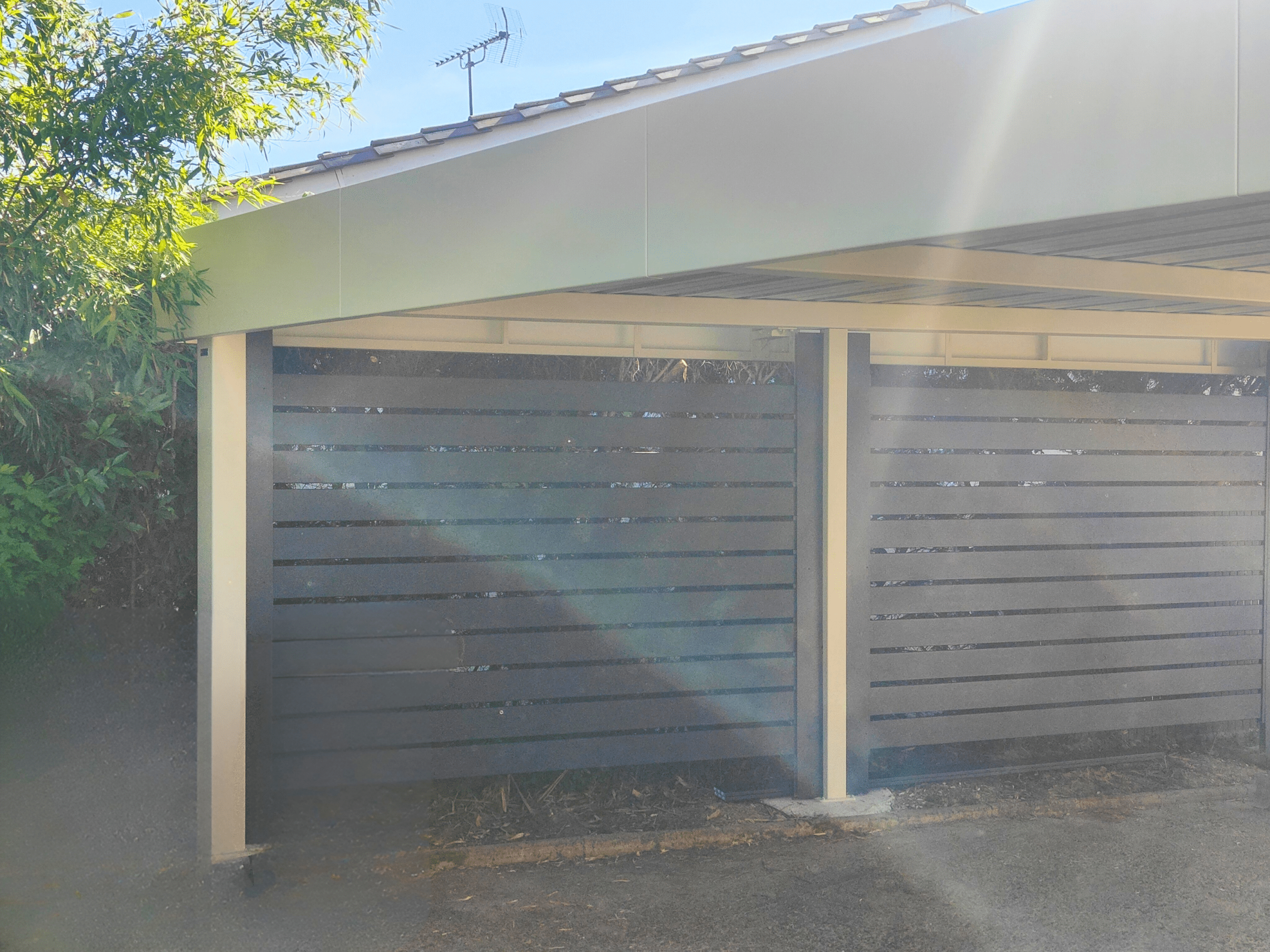 Carport aluminium sur mesure, moderne, à toit plat et bandeaux périphériques.