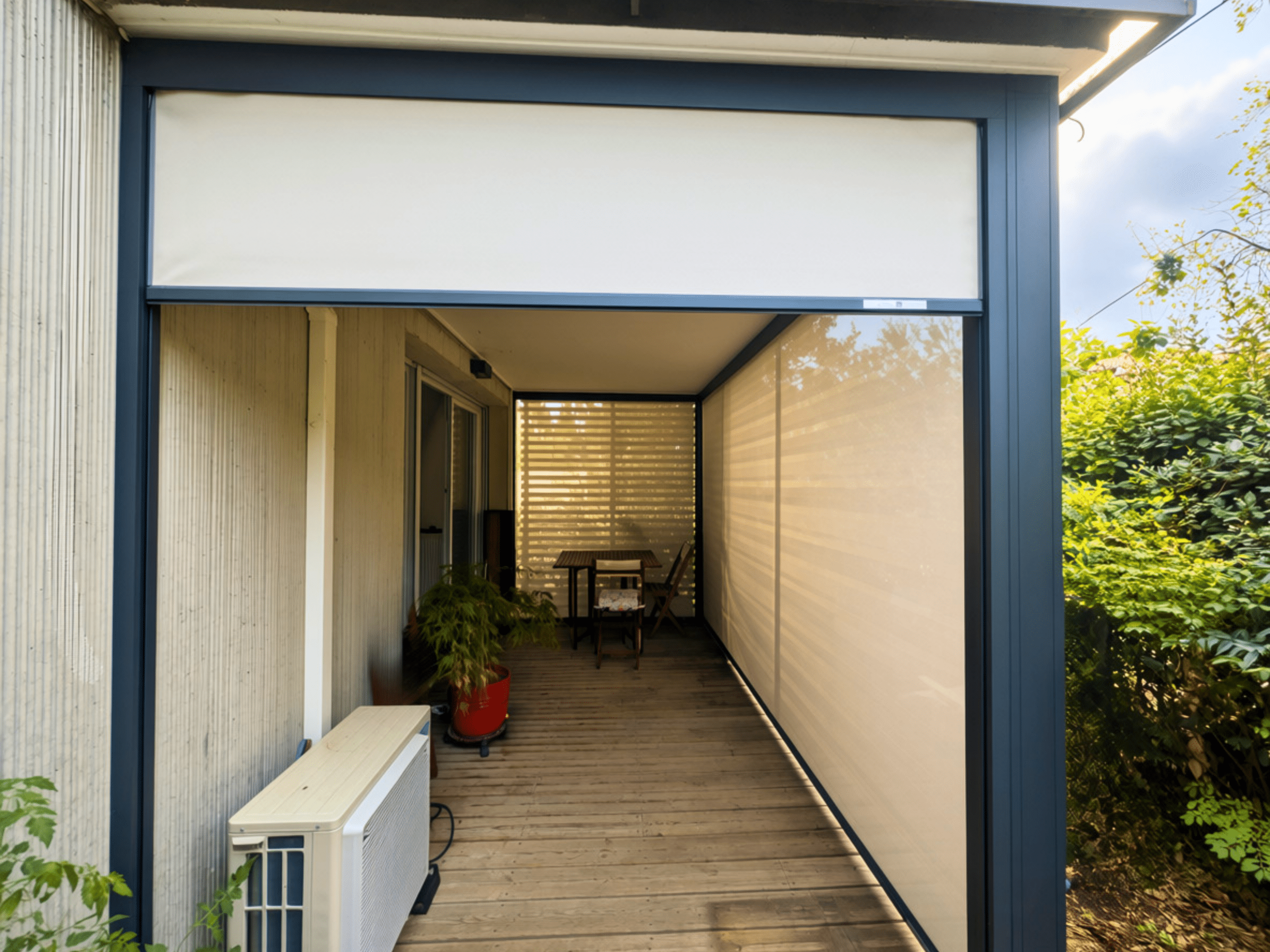 Terrasse avec aménagement sur mesure de stores verticaux extérieurs beiges rétractables, plancher en bois et mobilier de jardin.